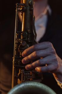 A detailed shot of a saxophonist performing with a brass saxophone, highlighting hand position.